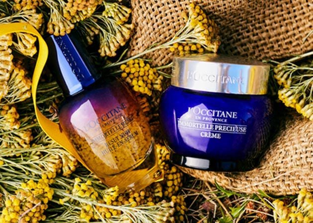 immortelle reset serum and precious cream lying in sack of immortelle flowers